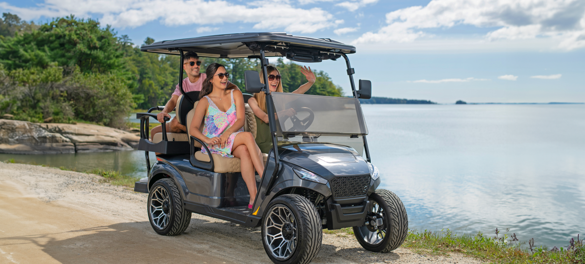 Woman driving golf cart past lakefront